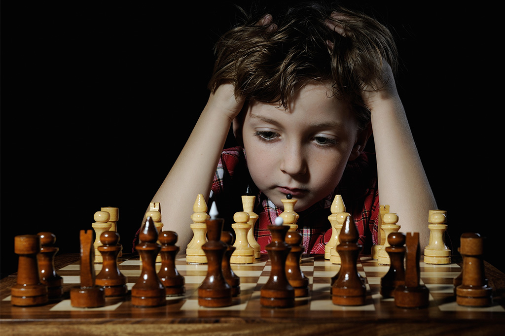 young child concentrates to play chess