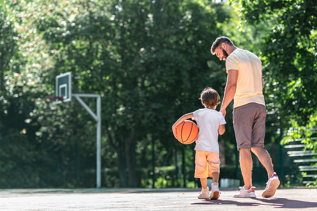 father and son play basketball