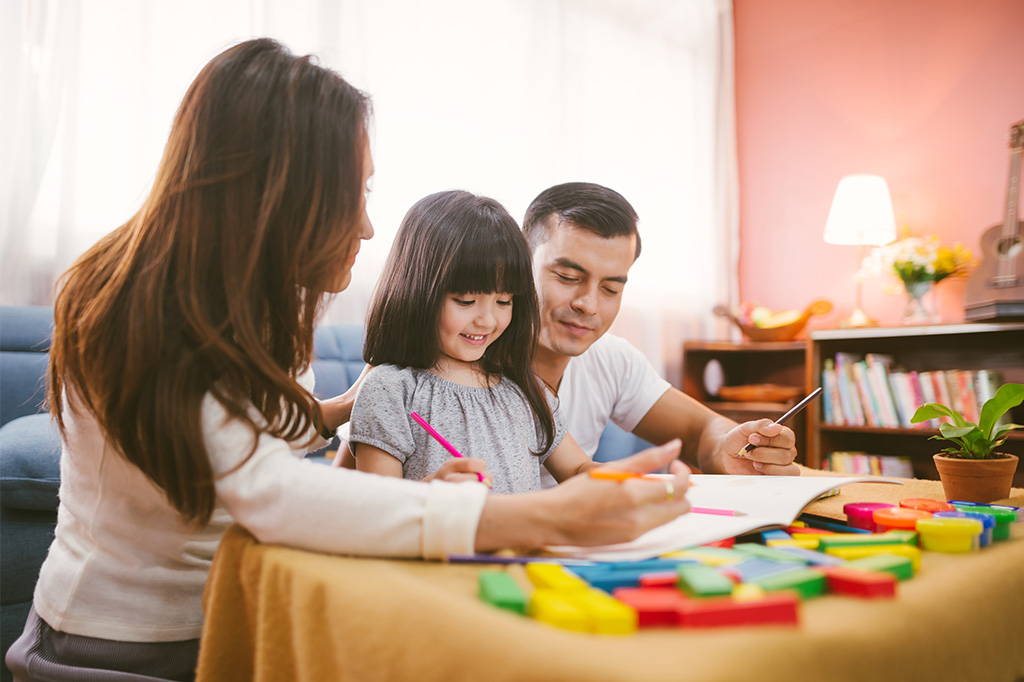 happy child learning at home with parents