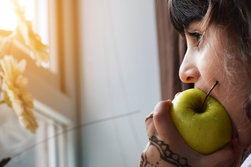 Child bites an apple