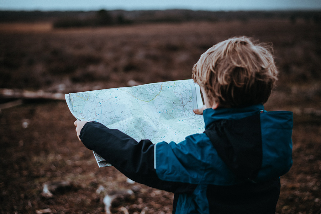 adventurous young child reads map